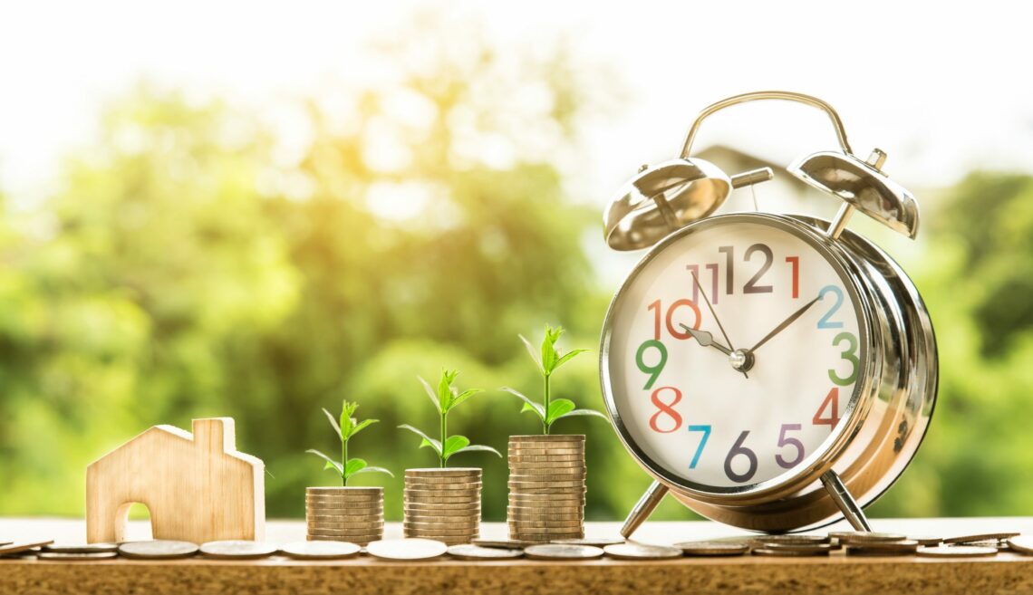 Coins and clock stacked on table